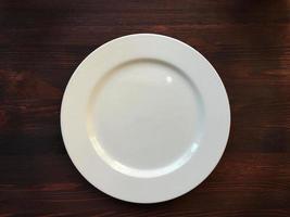 piatto bianco vuoto sul tavolo di legno foto