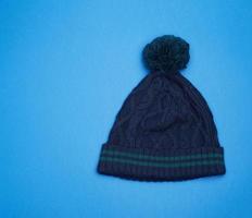 buio blu a maglia cappello con pompon su un' blu sfondo foto