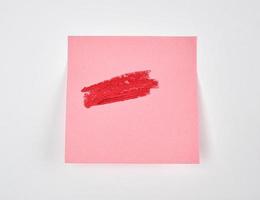 sbavature di rosso rossetto su un' rosa carta etichetta foto