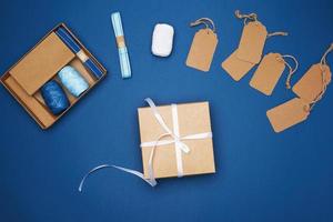 Marrone cartone scatola legato con un' bianca nastro e un' impostato per Imballaggio vacanza i regali foto