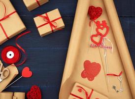 Marrone kraft carta, confezionato regalo borse e legato con un' rosso nastro, rosso cuore, impostato di elementi per fabbricazione i regali foto