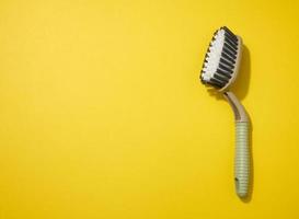 plastica spazzola con maniglia per pulizia il Casa su un' giallo sfondo, superiore Visualizza foto