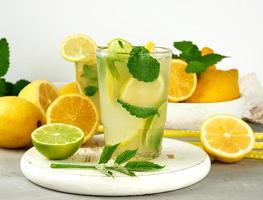 estate rinfrescante bevanda limonata con limoni, menta foglie, lime nel un' bicchiere foto