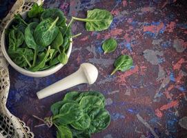 fresco verde spinaci le foglie nel un' bianca ceramica mortaio foto