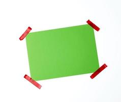 vuoto verde foglio di carta incollato con rosso appiccicoso nastro foto