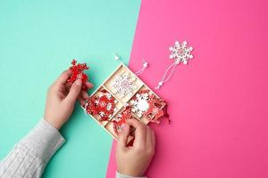 Due femmina mani e di legno lavorato Natale decorazioni per il vacanza albero foto