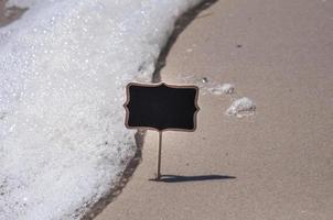 vuoto di legno nero cartello su il spiaggia foto