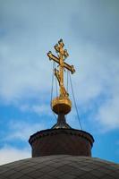 oro attraversare su il cupola di il Chiesa foto