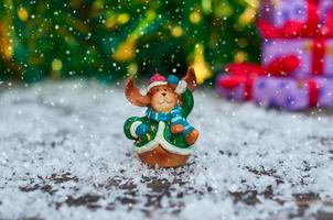 ceramica Natale giocattolo alce nel festivo Abiti in piedi nel il neve, il neve su superiore di lanci foto