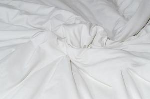 bianca spiegazzato o rugosa biancheria da letto foglio o coperta con modello dopo ospiti uso prese nel Hotel, ricorrere camera con copia spazio, disordinata coperta sfondo struttura foto