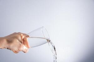 versando acqua dal bicchiere foto