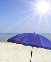 tessile blu ombrello su il sfondo di il mare foto