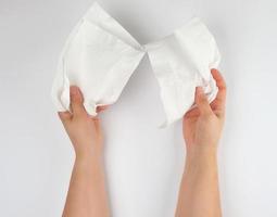 femmina mani Tenere un' pulito bianca carta tovagliolo per viso e corpo foto