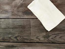 bianca cucina tessile asciugamano piegato su un' grigio di legno tavolo a partire dal vecchio tavole, superiore Visualizza, vuoto spazio foto