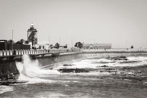 le onde rimbalzano contro la protezione delle onde, il frangiflutti, la città del capo di Sea Point. foto