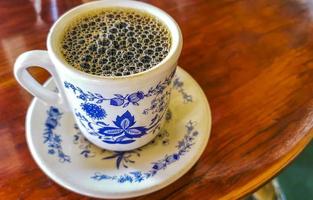 blu bianca tazza pentola con nero caffè di legno tavolo Messico. foto