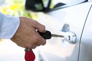 auto proprietario con chiave. Noleggio un' macchina, acquisto un' macchina, vendita un' auto concetto foto