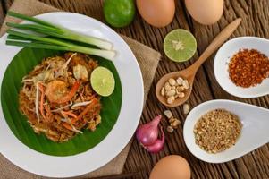 pad thai gamberetti in una ciotola con uova, cipollotto e condimenti foto