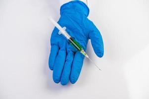 scienziato che indossa guanti che tengono una siringa con un vaccino per prevenire il covid-19 foto