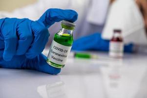 scienziato che mostra fiale con vaccini per proteggersi da covid-19