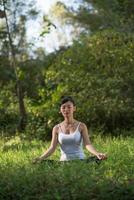 donna in posa yoga all'aperto nella natura foto