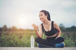 adolescente fitness con auricolari ascoltando musica durante il suo allenamento foto