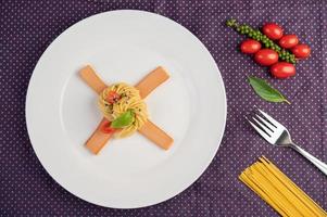 spaghetti gourmet splendidamente disposti su un piatto bianco foto