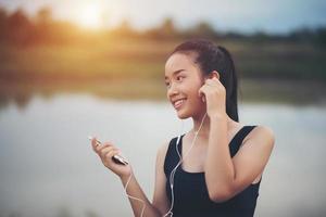 adolescente fitness con auricolari ascoltando musica durante il suo allenamento