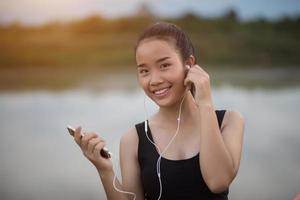 adolescente fitness con auricolari ascoltando musica durante il suo allenamento foto