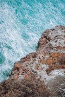 roccia vicino all'acqua blu foto