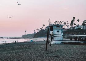 california, 2020 - casa bianca e rossa del bagnino sulla spiaggia durante il giorno foto