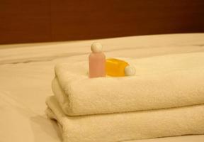 lussuosa camera da letto con due asciugamani e shampoo sul letto foto