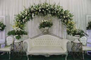interno decorazione impostato su per giavanese nozze con un' lotto di fresco fiori. foto