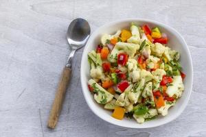 salutare cavolfiore insalata nel bianca ciotola su legna sfondo. foto