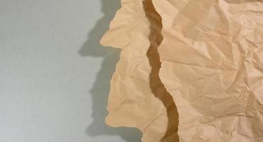 menta Marrone pezzo di carta con strappato bordi e ombra su grigio sfondo. astratto creativo fondale per progettista foto