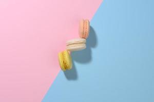 il giro multicolore macarons su un' rosa-blu sfondo con un' ombra. buongustaio mandorla Farina dolce foto