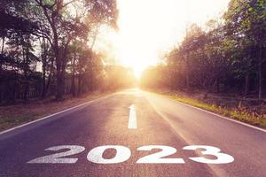 vuoto asfalto strada e nuovo anno 2023 concetto. guida su un vuoto strada per obiettivi 2023 con tramonto. foto