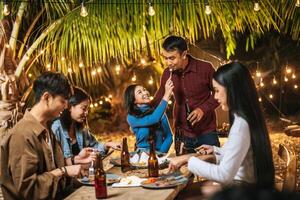 contento asiatico amici applauso con arrostito tacchino cena all'aperto - gruppo di persone avendo divertimento nel nuovo anno festa. le persone, cibo e bevanda stile di vita concetto notte festa, persone e celebrazione concetto. foto