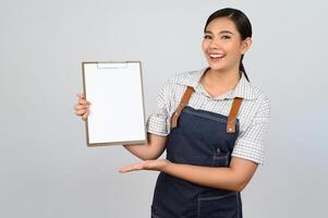 ritratto di giovane asiatico donna nel cameriera uniforme posa con appunti foto