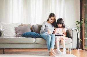 madre e figlia che leggono un libro foto