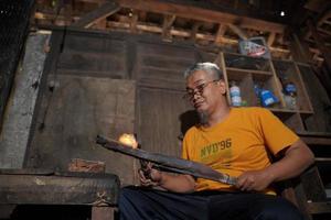 artigiani siamo fabbricazione keris nel il officina. giavanese tradizionale arma. banto, Indonesia - 25 agosto 2022 foto