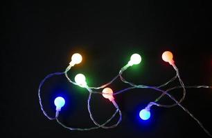 Natale sfondo con luci e spazio per gratuito testo. Natale luci confine. raggiante colorato Natale luci su un' nero sfondo. foto