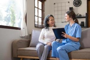 asiatico infermiera mostrando Salute verifica rapporto per nonna e dando consiglio. medico Assistito vivente visitare anziano paziente a casa. casa assistenza infermieristica e assistenza sanitaria badante concetto foto