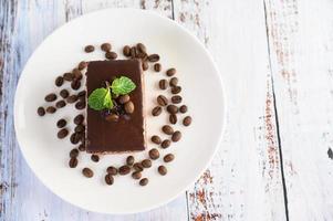 torta al cioccolato con chicchi di caffè su una superficie di legno foto