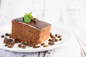 torta al cioccolato con chicchi di caffè su una superficie di legno foto