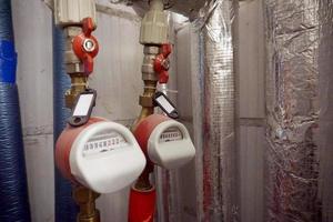 caldo e freddo acqua flusso metri installato su tubi foto