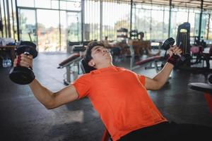 giovane uomo Lavorando su con manubri nel il Palestra foto