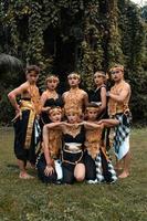 un' gruppo di balinese persone pose insieme con un' contento viso mentre indossare d'oro costumi dopo il prestazione foto