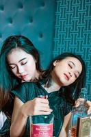asiatico donne Tenere un alcool bottiglia nel loro mano nel il Camera da letto foto