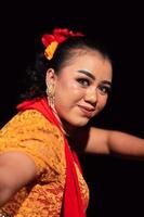 bellissimo viso di un indonesiano donna nel trucco mentre danza un' tradizionale danza nel un arancia costume durante il Festival foto